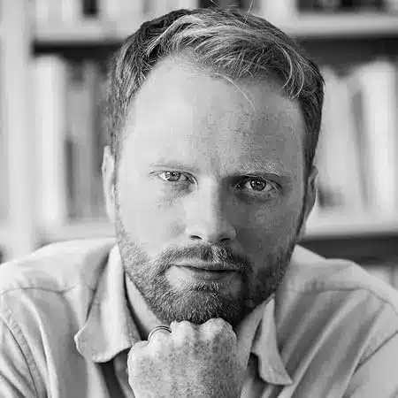 7 author Shoutouts Richard Swan with thoughtful expression in grayscale.