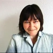 7 author Shoutouts Ali Smith grinning with long hair and casual jacket.