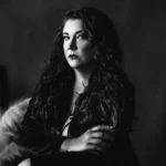 Dark Sisters Dark Sisters author Kristi DeMeester a woman with curly hair in shadows