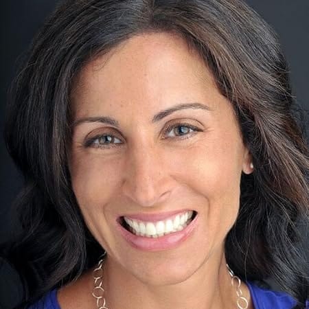 More or Less Maddy author Lisa Genova smiling with long brunette hair and necklace