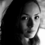 The Old Fire author Elisa Shua Dusapin grayscale portrait with long, dark, wavy hair.
