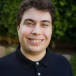 Upward Bound author Woody Brown in black polo shirt outdoors.