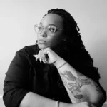 Year of the Mer author L. D. Lewis with arm tattoo and long hair