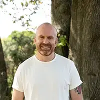 The Midnight Train author Matt Haig smiling in a natural setting.