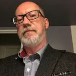 Red X author David Demchuk with glasses and beard