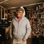 The Double Dutch Fuss author Phill Branch smiling in a library setting.