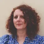 Land author Maggie O'Farrell with curly hair, blue blouse