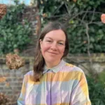 Natural Disaster author Lisa Owens smiling in colorful shirt