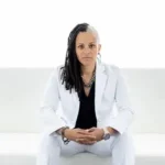 Sex in Public author Angela Jones in white suit, serious expression.