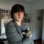 Last Day of a Prior Life author Andres Barba holding a cat indoors.