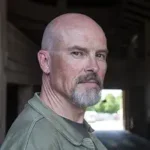 Last Days author Adam Nevill with a beard in shadows