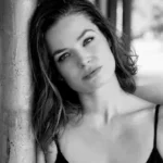 Roadshow author Nikki Ervice in black and white portrait leaning against a pillar.