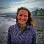 Long Wave Long Wave author Daisy Johnson smiling by the beach.